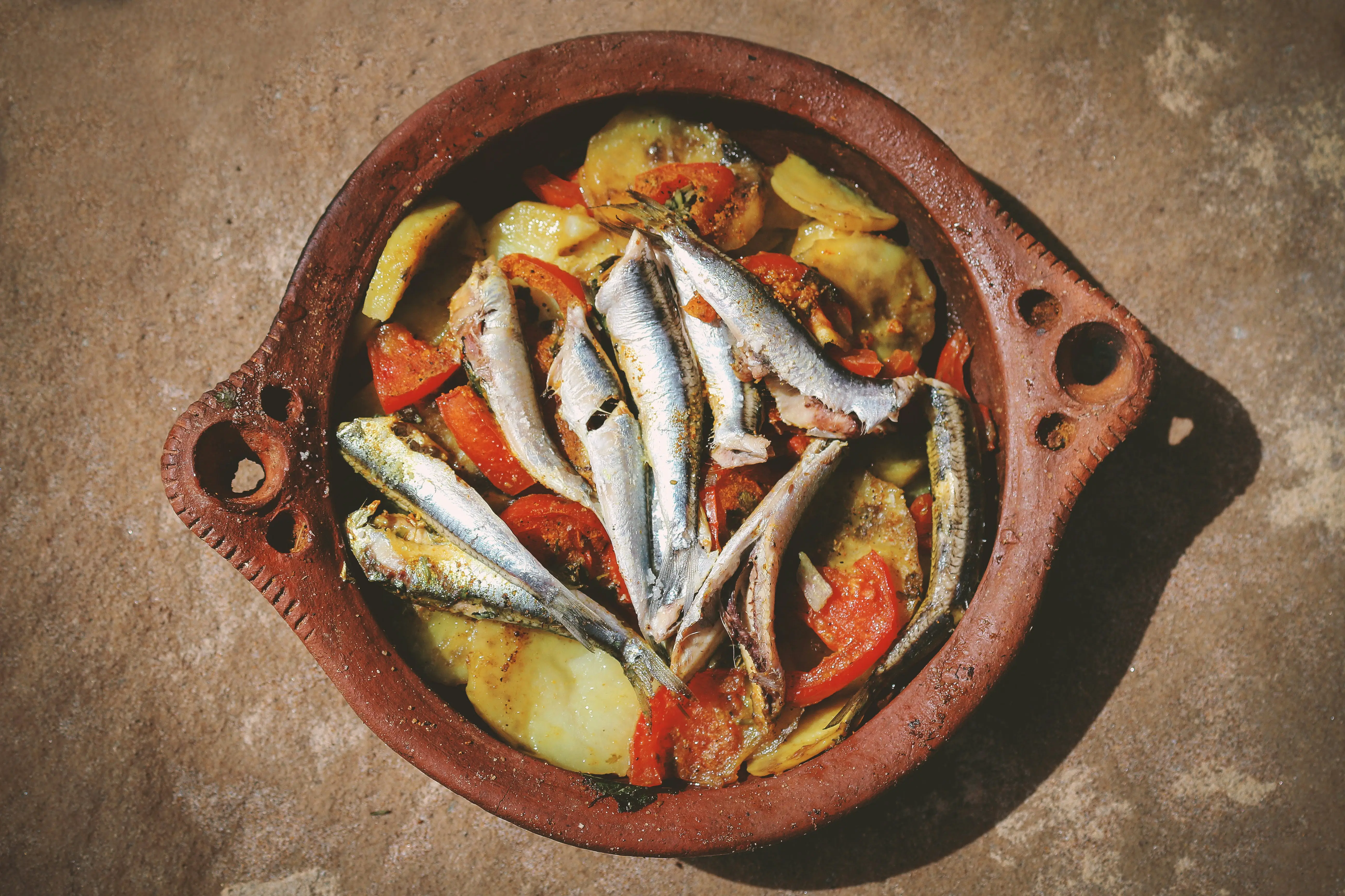 Traditional Moroccan tagine with colorful vegetables and spices served in authentic clay pot with fresh bread and mint tea